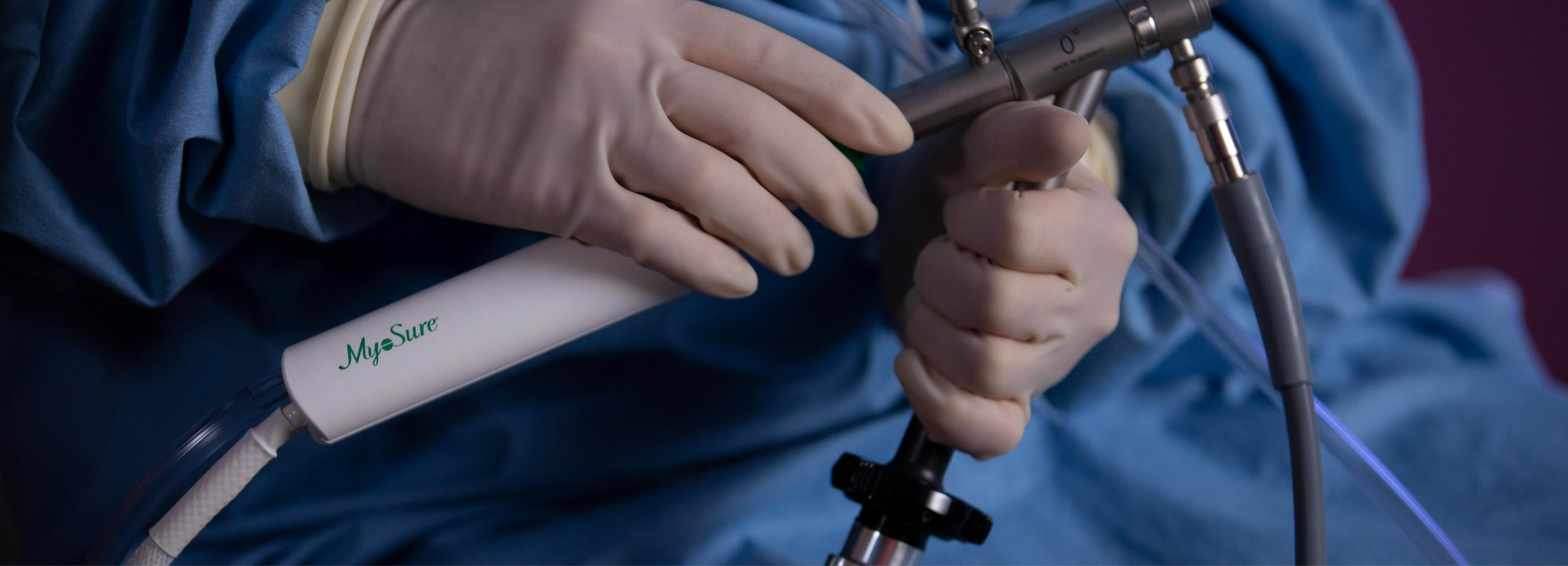 Behandskede hænder holder en medicinsk enhed