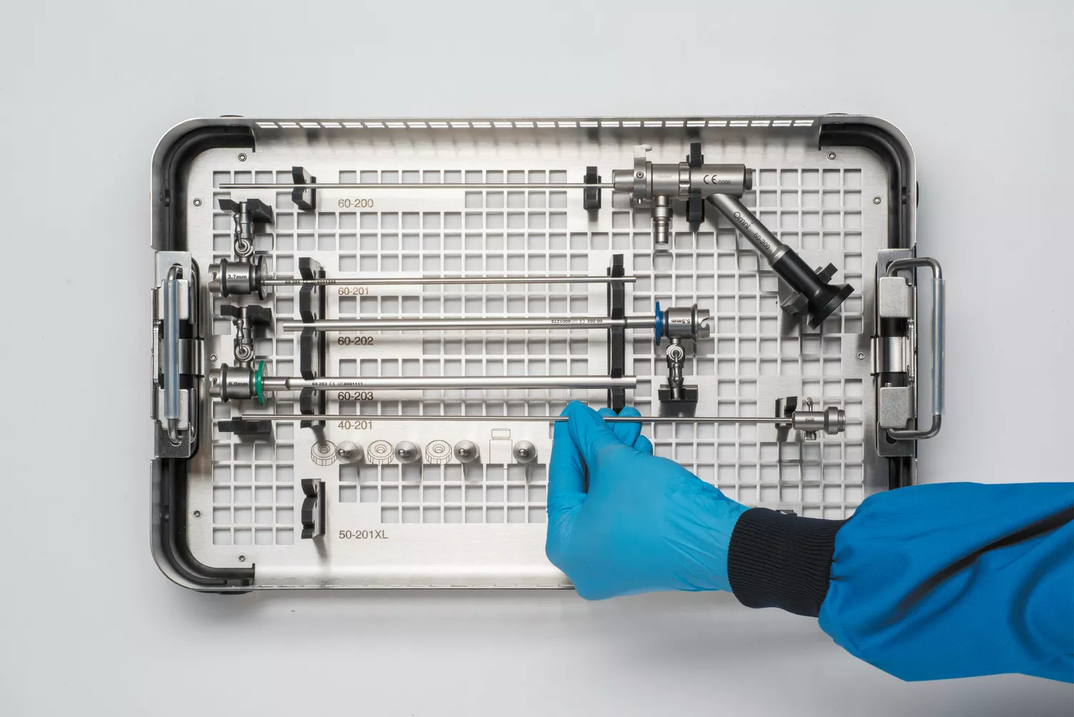 Behandsket hånd arbejder på en medicinsk bakke på et bord.